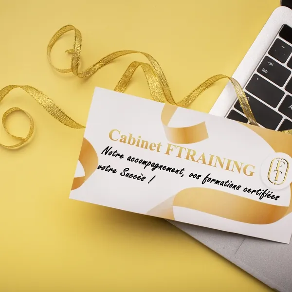 sur fond jaune une carte voeux avec ruban doré sur un ordinateur avec écrit cabinet ftraining notre accompagnement vos formations certifiées votre succes
